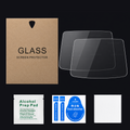 A set of screen protector accessories on a black background, including two clear glass screen protectors, a brown kraft paper bag labeled 'GLASS SCREEN PROTECTOR,' a white alcohol prep pad packet, a blue dust absorber packet, and a white microfiber cloth.